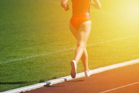 Athletics woman running on the track fieldの写真素材