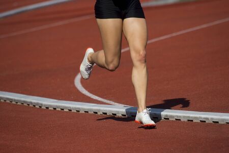 Athletics woman running on the track fieldの写真素材