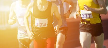 Athletics people running on the track field. Sunny dayの写真素材