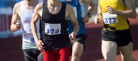 Athletics people running on the track field. Sunny dayの写真素材