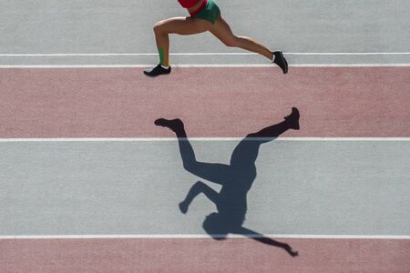one caucasian woman runner jogger running in silhouette  on stadium backgroundの写真素材