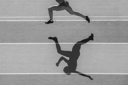 one caucasian woman runner jogger running in silhouette  on stadium background. Black and white color.の写真素材