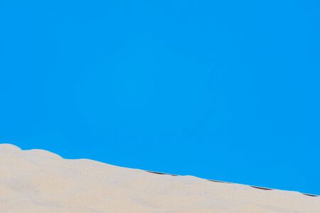 Football, volleyball, handball summer sport. Sandy beach on blue background with copy space for textの写真素材