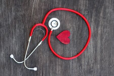 Stethoscope and red heart on wooden background. Health care conceptの写真素材
