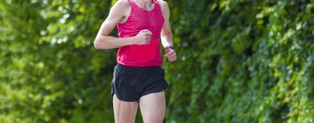 Young sporty man running on sunny dayの写真素材