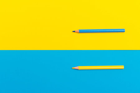 Back to scool - Pencils detail. Colored sharp pencils detail in a row, isolated on blue and yellow