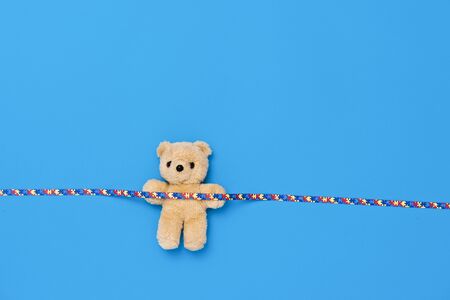 World Autism Awareness day, mental health care concept with teddy bear and ribbon puzzle pattern. On blue backgroundの写真素材