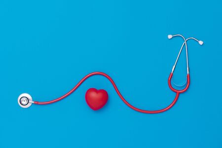 Red heart with stethoscope on blue background. Copy space. Valentines day.の写真素材