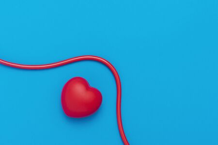 Red heart with stethoscope on blue background. Copy space. Valentines day.の写真素材