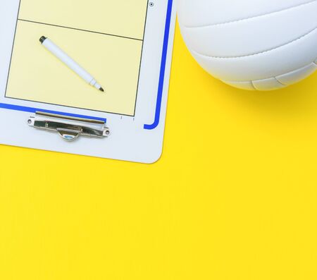 Volleyball and tactical board with marker on yellow background. Top viewの写真素材