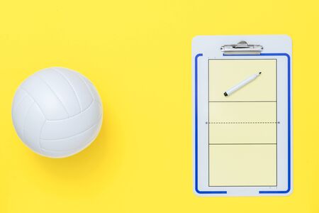 Volleyball and tactical board with marker on yellow background. Top viewの写真素材