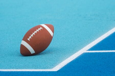Ball for American Football on blue court, outdoor. American Football ball on a blue multifunctional sport outdoor courtの写真素材