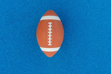 Ball for American Football on blue court, outdoor. American Football ball on a blue multifunctional sport outdoor courtの写真素材