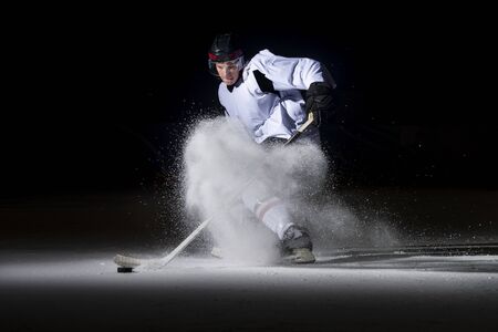 Ice hockey player in action kicking with stickの写真素材