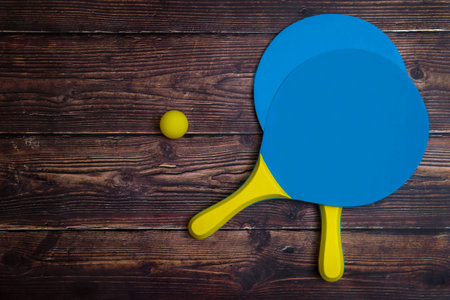Beach Tennis Racket Set. Beach paddle tennis racket set with rubber ball, on a wooden background
