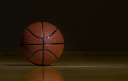 Basketball On Hardwood Court Floor With Spot Lightingの写真素材