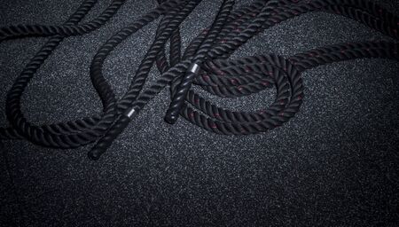 Close up of black battle rope on a gray backgound. Sport and fitness equipment. Functional trainingの写真素材