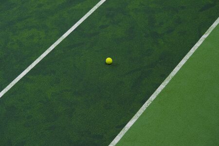 Tennis ball near the line on tennis grass court from top view.の写真素材
