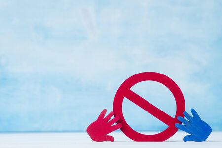 Red forbidden sign and hand  on blue background.の写真素材