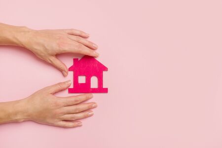 Hand Holding Pink house on pink background. New home conceptの写真素材