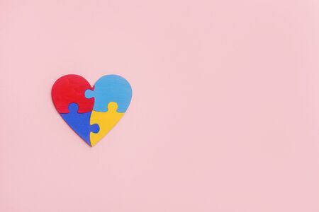 Puzzle pieces in form of heart, isolated on pink background. World Autism Awareness Day Conceptの写真素材