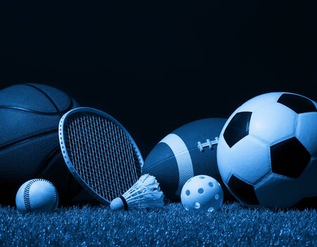 Sports equipment, rackets and balls on green grass with black background and copy space.の写真素材