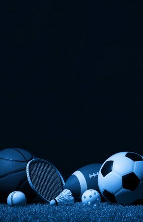 Sports equipment, rackets and balls on green grass with black background and copy space.の写真素材