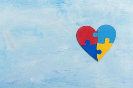 Puzzle pieces in form of heart, isolated on blue background. World Autism Awareness Day Conceptの写真素材