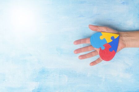 Hand Holding Colorful Heart On Blue Background. World Autism Awareness Day Conceptの写真素材