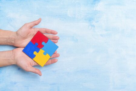 hands playing a puzzle symbol of Public awareness for autism spectrum disorder.の写真素材