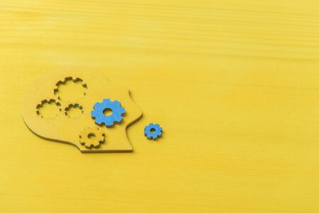 Brain works concept. Thinking, creativity concept of the human head with gears on yellow backgroundの写真素材