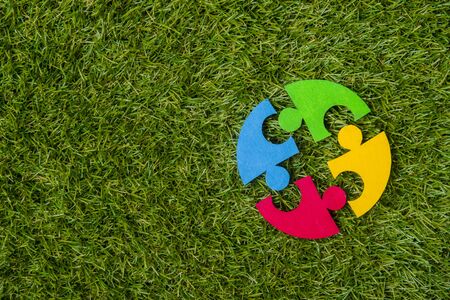 Colorfull puzzles piece on green grass background. World Autism Awareness Day Conceptの写真素材