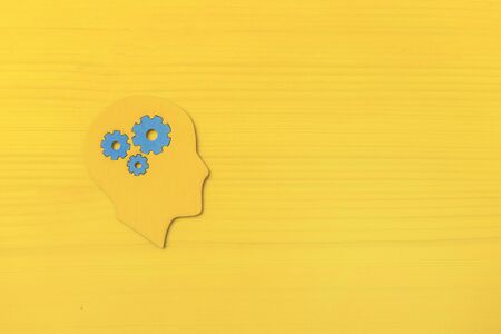 Brain works concept. Thinking, creativity concept of the human head with gears on yellow backgroundの写真素材