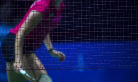 Badminton net indoor on badminton court, closeup view of badminton net with player blurry background.の写真素材