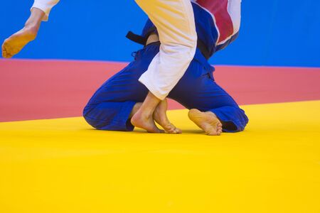 Two judo fighters in white and blue uniformの写真素材