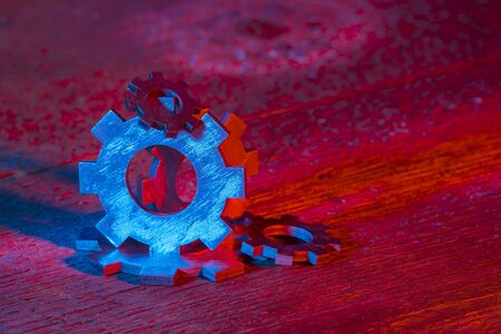 Gears on the wooden background. Machine part. Neon color.の写真素材