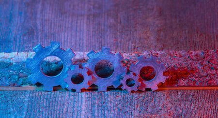Gears on the wooden background. Machine part. Neon color.の写真素材