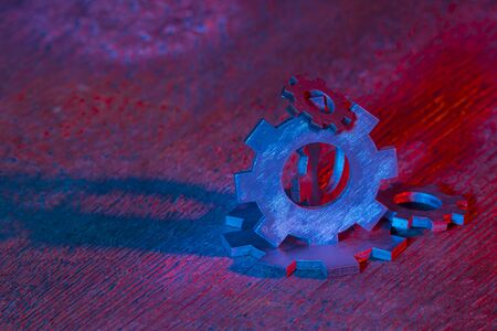 Gears on the wooden background. Machine part. Neon color.の写真素材
