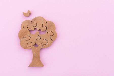 Wooden tree and bird puzzle over pink backgroundの写真素材