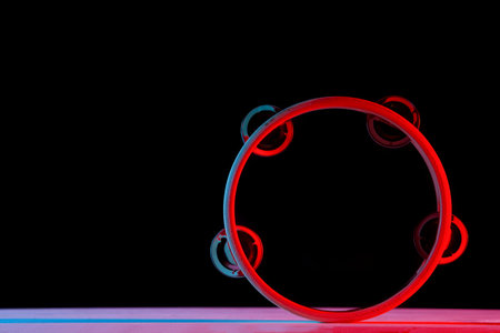 Tambourine isolated on black background.Single classical music instrument. Red neon Banner Art conceptの写真素材
