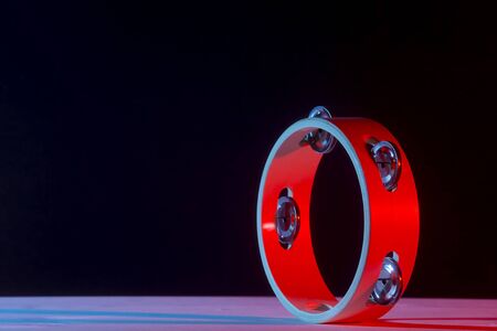 Tambourine isolated on black background.Single classical music instrument. Red neon Banner Art conceptの写真素材