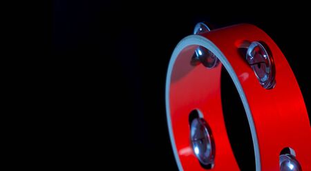 Tambourine isolated on black background.Single classical music instrument. Red neon Banner Art conceptの写真素材