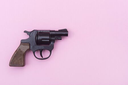 Black gun on a pink background.の写真素材