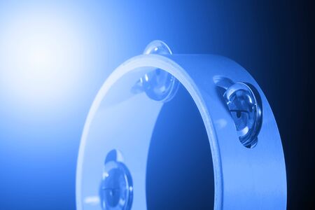 Tambourine isolated on black background. Blue filter. Single classical music instrument.の写真素材