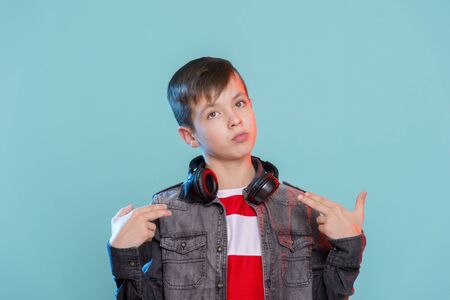 Kid listening music headphones. Music beat concept. Entertainment and fun. Child or teen enjoy music.の写真素材