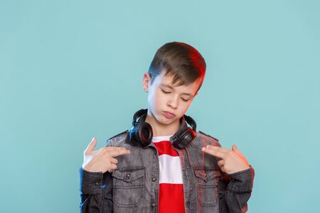 Kid listening music headphones. Music beat concept. Entertainment and fun. Child or teen enjoy music.の写真素材