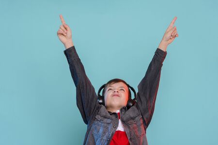 Kid listening music headphones. Music beat concept. Entertainment and fun. Child or teen enjoy music.の写真素材