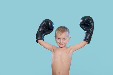 Happy little kid with black boxing glovesの写真素材