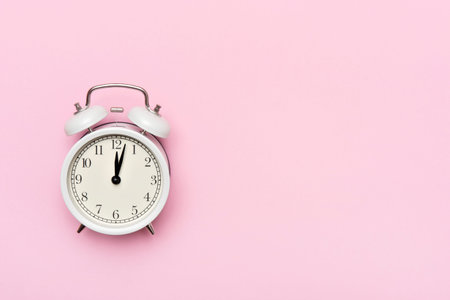 Retro alarm clock or vintage alarm clock isolated on pink background