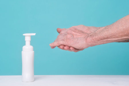 Old man using alcohol gel for cleaning hands. Pandemic protection, Hygienic and Health care concept